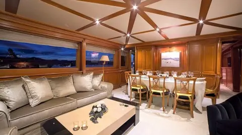Aquila luxury yacht interior with cream seating, wood panels, and dining area