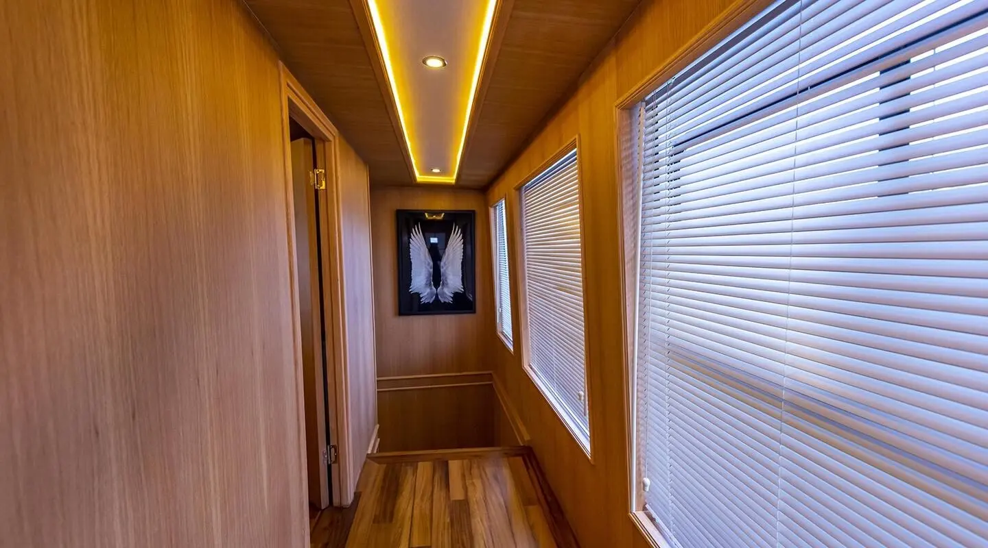 Interior hallway of a luxury yacht with wood paneling and warm lighting