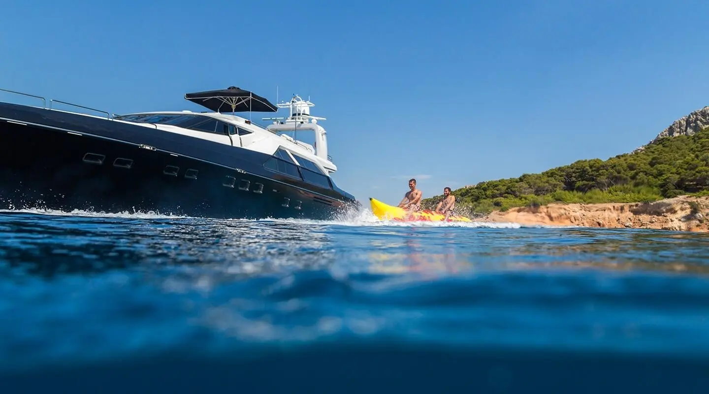 Yacht Aquarella anchored by coastline with clear blue water and a small boat nearby