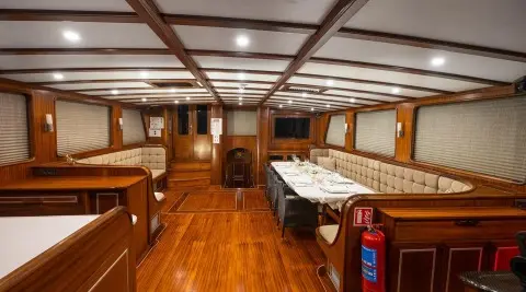 Gulet Estrella De Mar sailing yacht saloon with wooden flooring and dining table