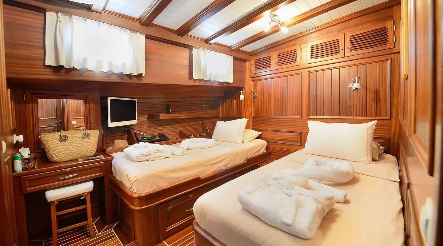 Interior of Zephyria II yacht with wooden walls, twin beds, and seating