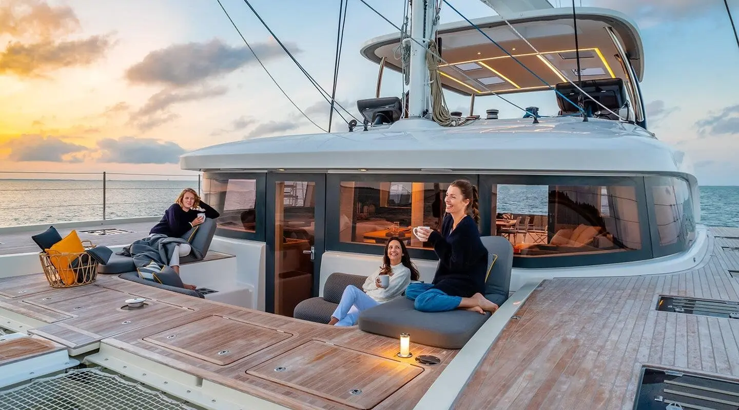 Yacht Daiquiri sunset deck: guests sit at wooden table on bow seating