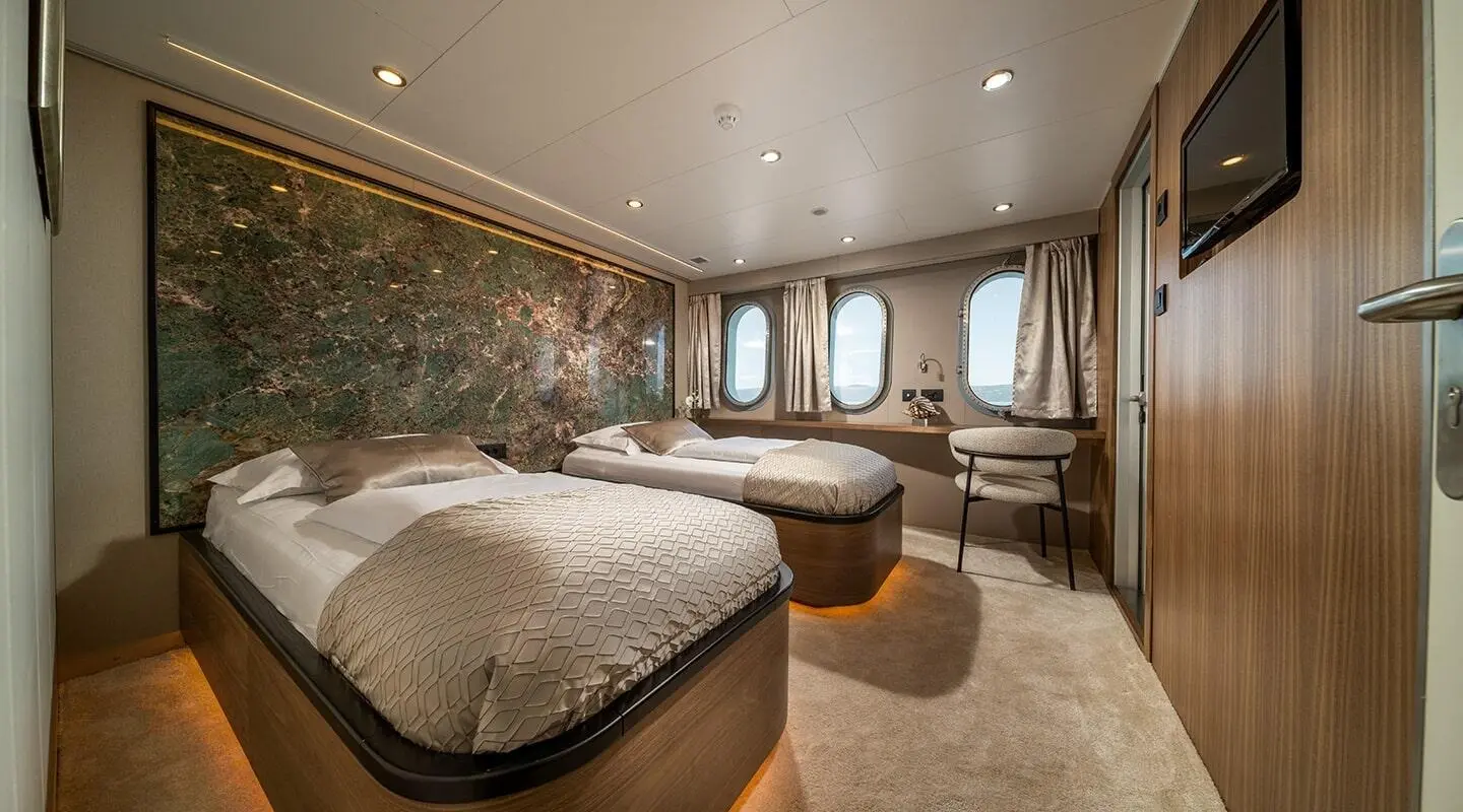 Olimp luxury yacht deck bedroom with round portholes and warm lighting