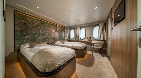Olimp luxury yacht deck bedroom with round portholes and warm lighting