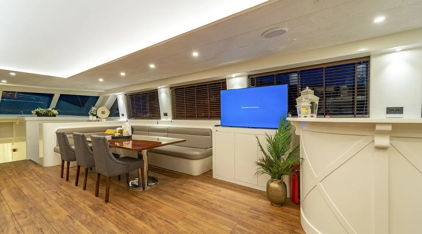 Interior lounge area of Queen Of Makri gulet with wooden flooring and seating