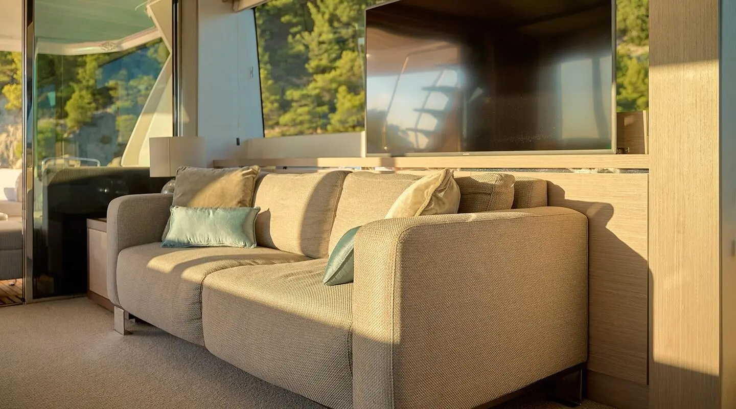 Interior of luxury motor yacht salon with beige seating and wood accents
