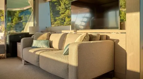 Interior of luxury motor yacht salon with beige seating and wood accents
