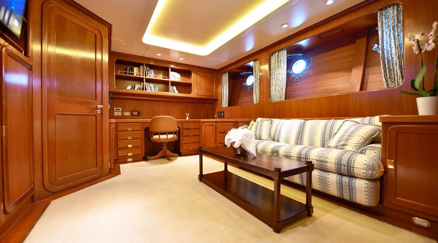 Tamarita luxury yacht saloon with leather sofas, wooden cabinetry, and a coffee table