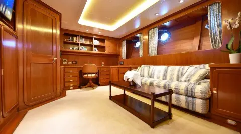 Tamarita luxury yacht saloon with leather sofas, wooden cabinetry, and a coffee table