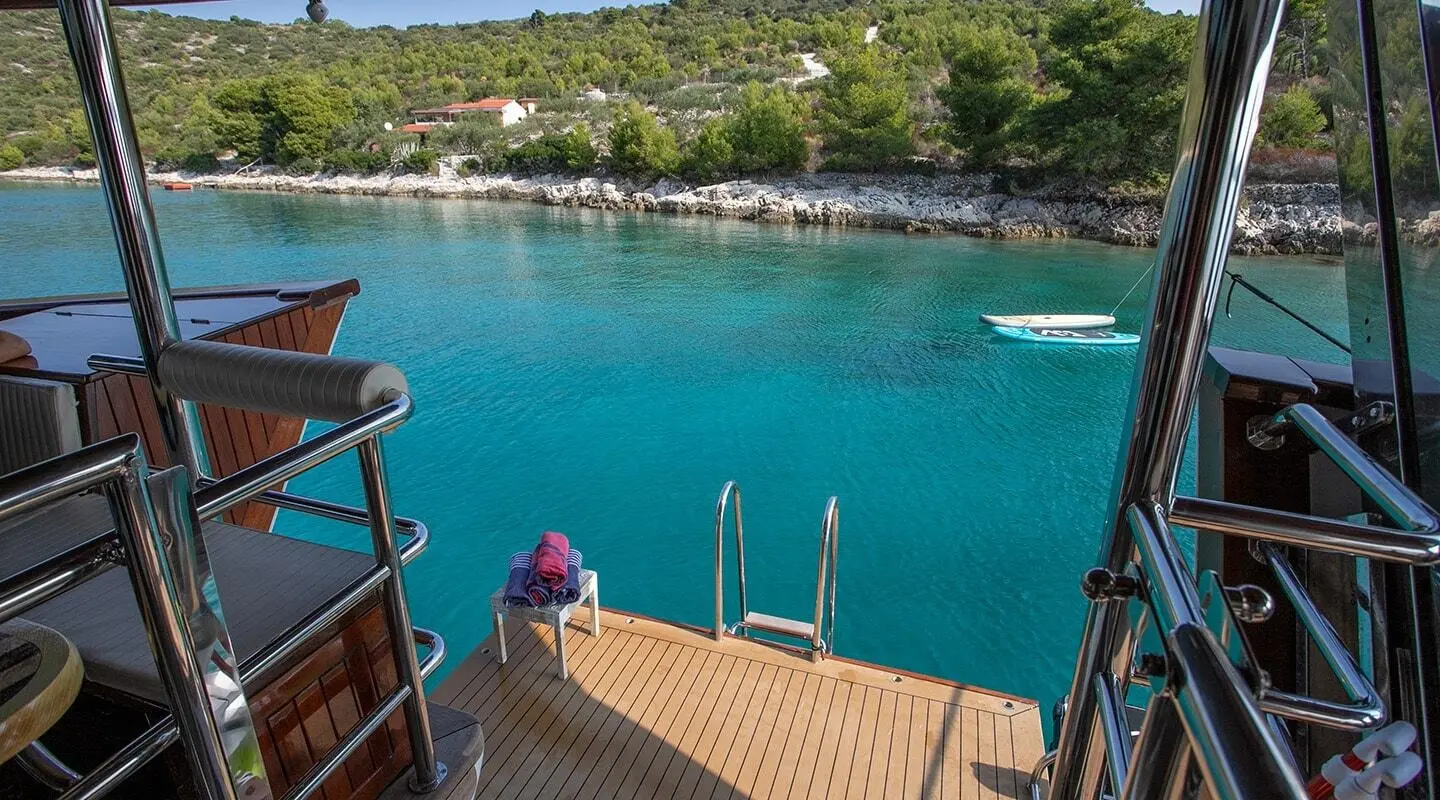 Amorena motor yacht docked with swim platform over blue water