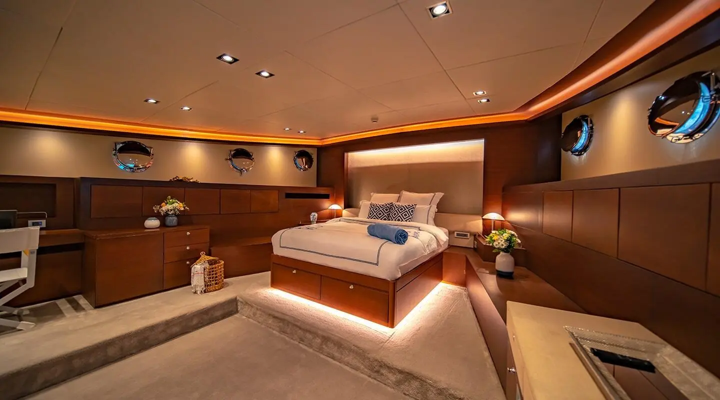 Luxurious yacht Double Eagle interior with bed, warm lighting, and wooden furnishings