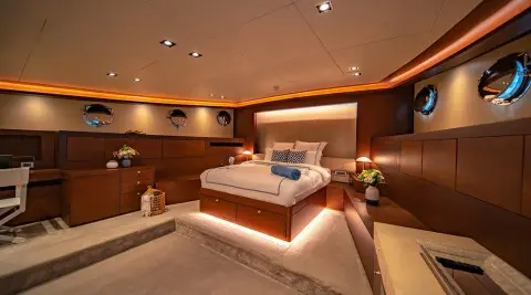Luxurious yacht Double Eagle interior with bed, warm lighting, and wooden furnishings