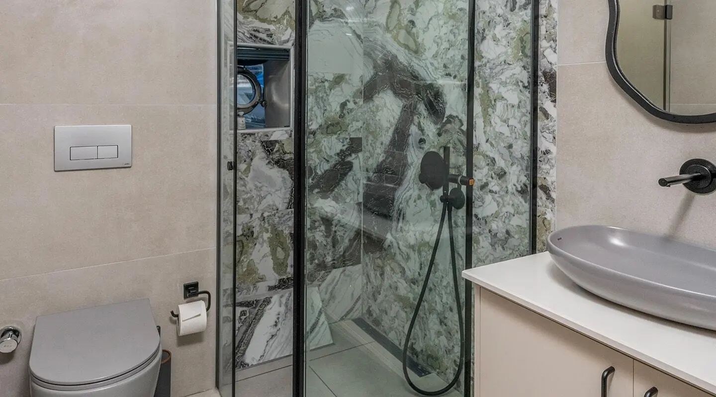 Shower area on Calm Down yacht with glass doors and marble-pattern walls