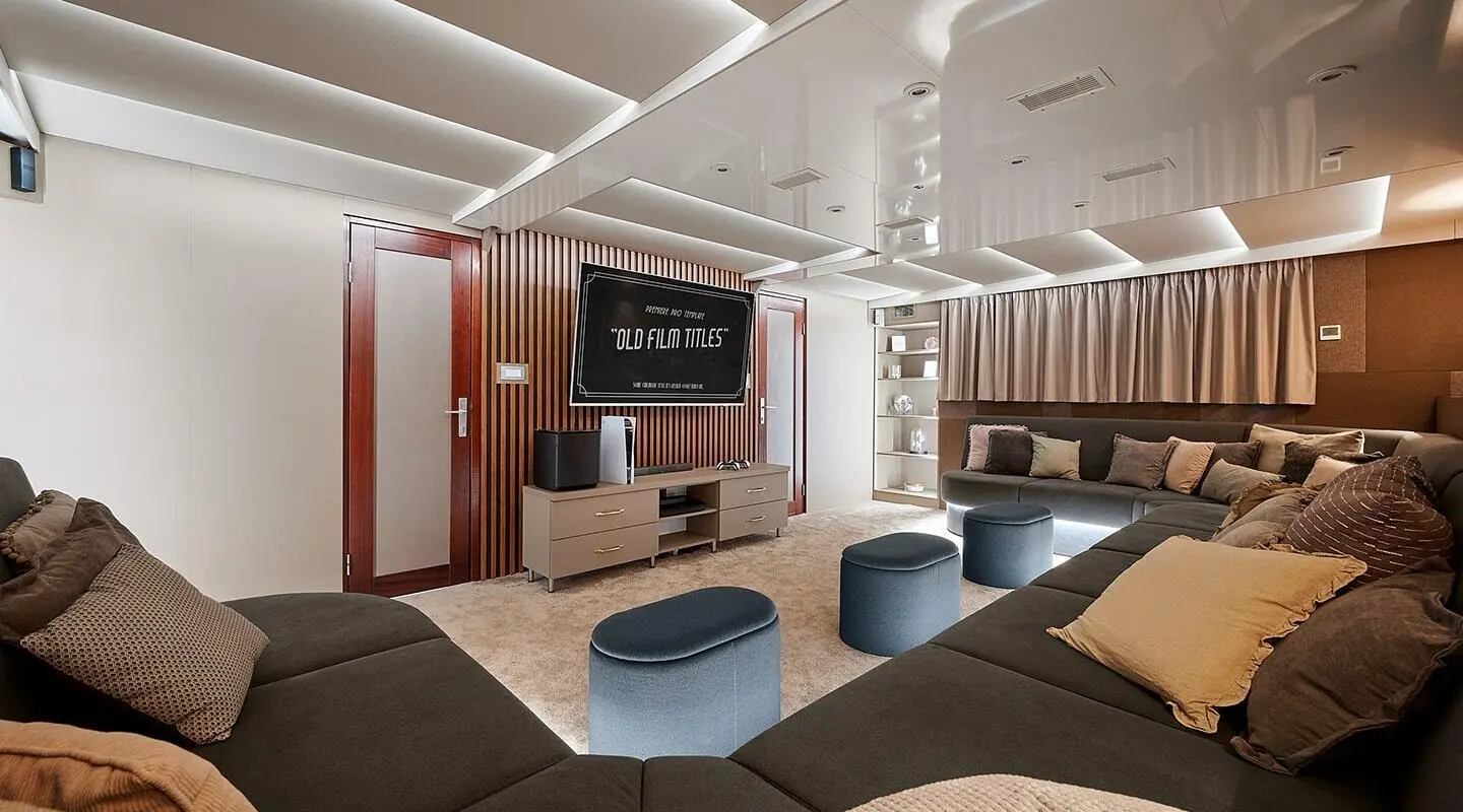 Lupus Mare yacht lounge interior with white seating, blue ottomans, and soft lighting