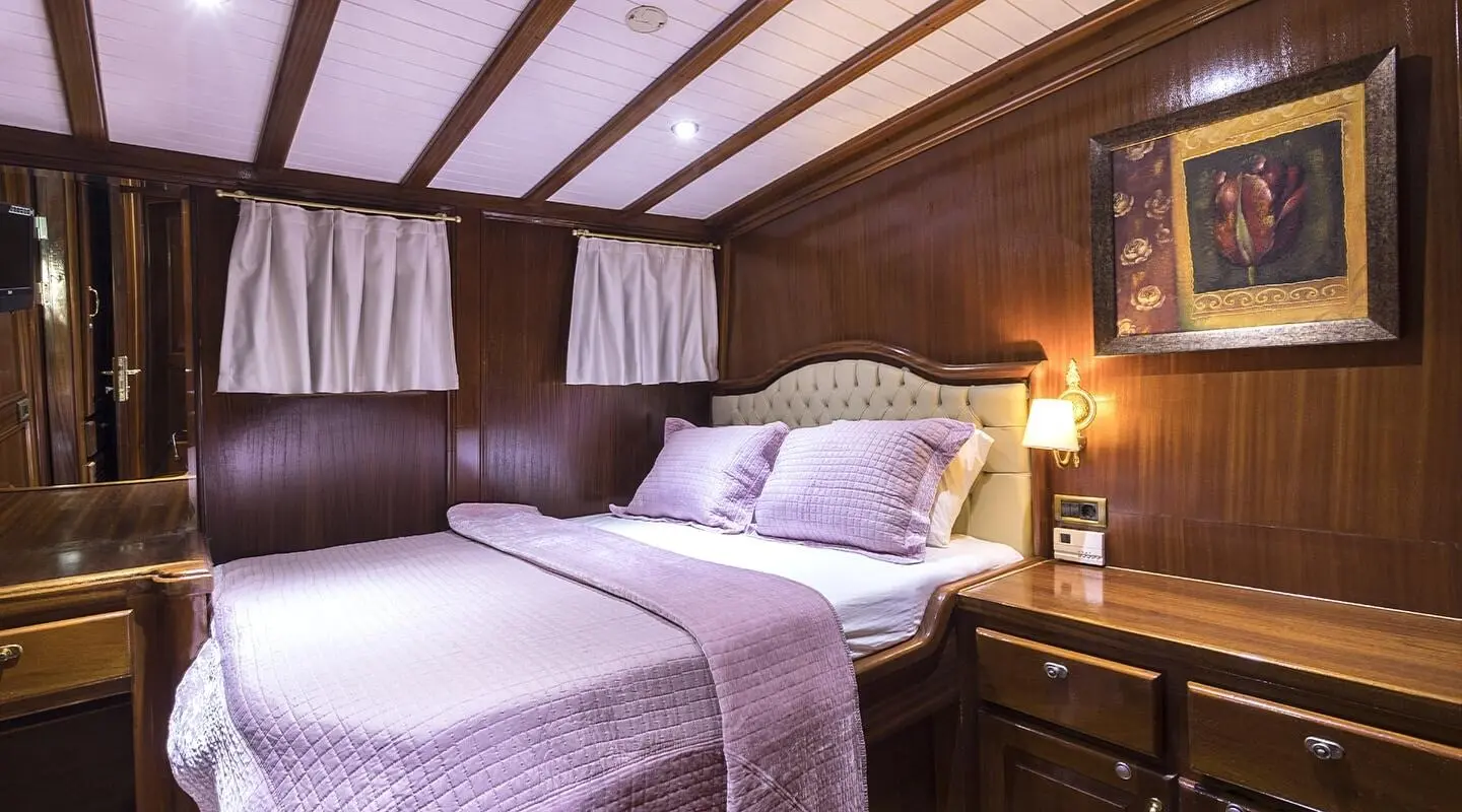 Grace 1 yacht interior with two single beds, wooden panels, and soft lighting