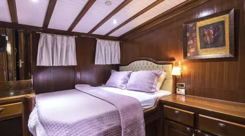 Grace 1 yacht interior with two single beds, wooden panels, and soft lighting
