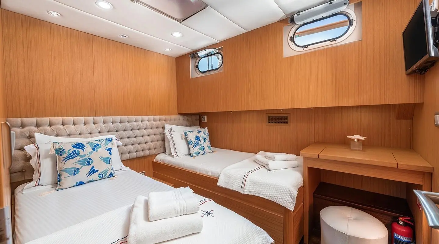 Artemis luxury yacht interior with wooden cabinetry, seating, and porthole