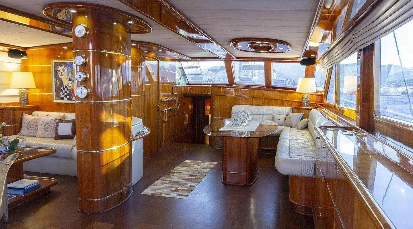 Luxurious gulet interior with wooden panels, seating area, and large windows