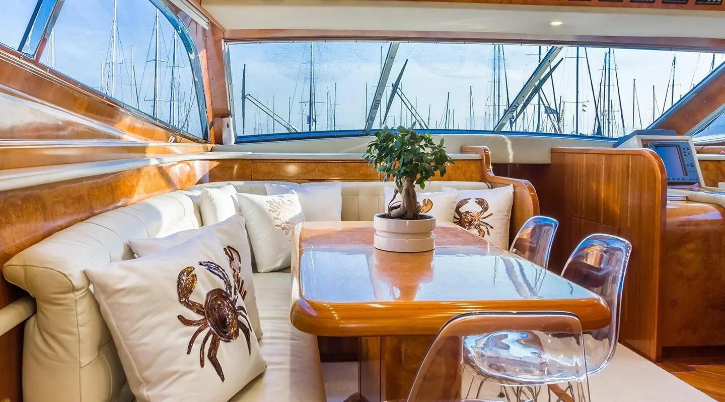 Aft seating area on Amoraki yacht with cushioned chairs and wooden table