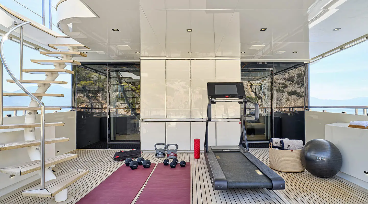 Fitness area on the upper deck with treadmill, dumbbells and exercise gear