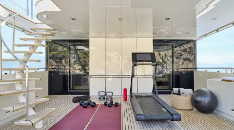 Fitness area on the upper deck with treadmill, dumbbells and exercise gear