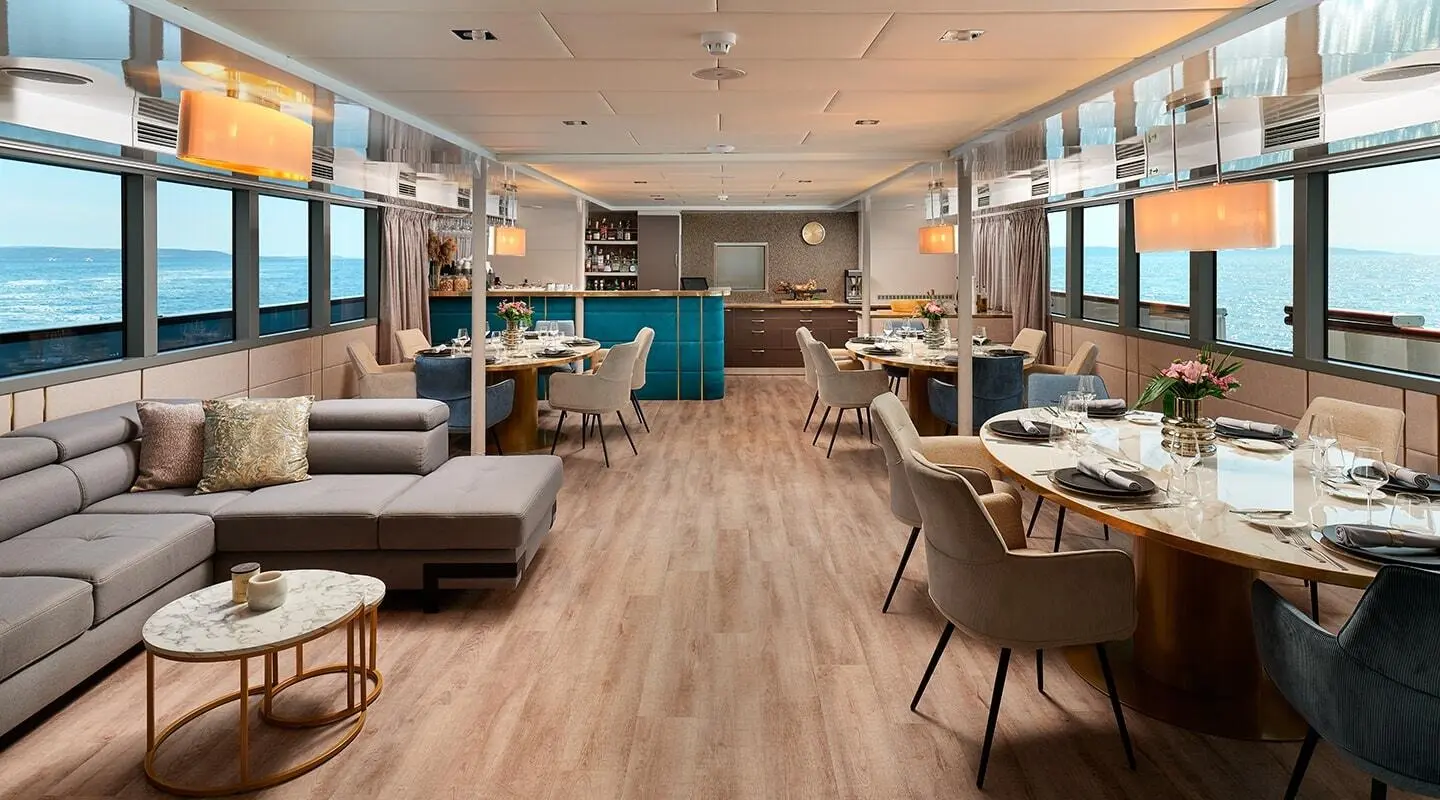 Interior salon of Ohana motoryat, blue seating, wooden floor, large windows