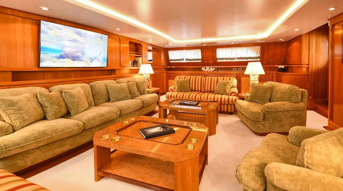 Tamarita yacht saloon interior with wooden furniture, sofas, and ambient lighting