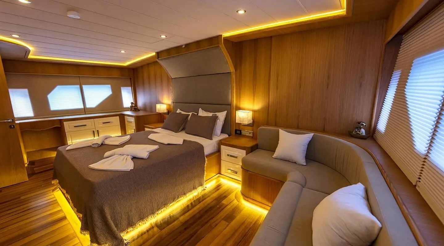 Wood-paneled cabin with bed and curved sofa, warm lighting