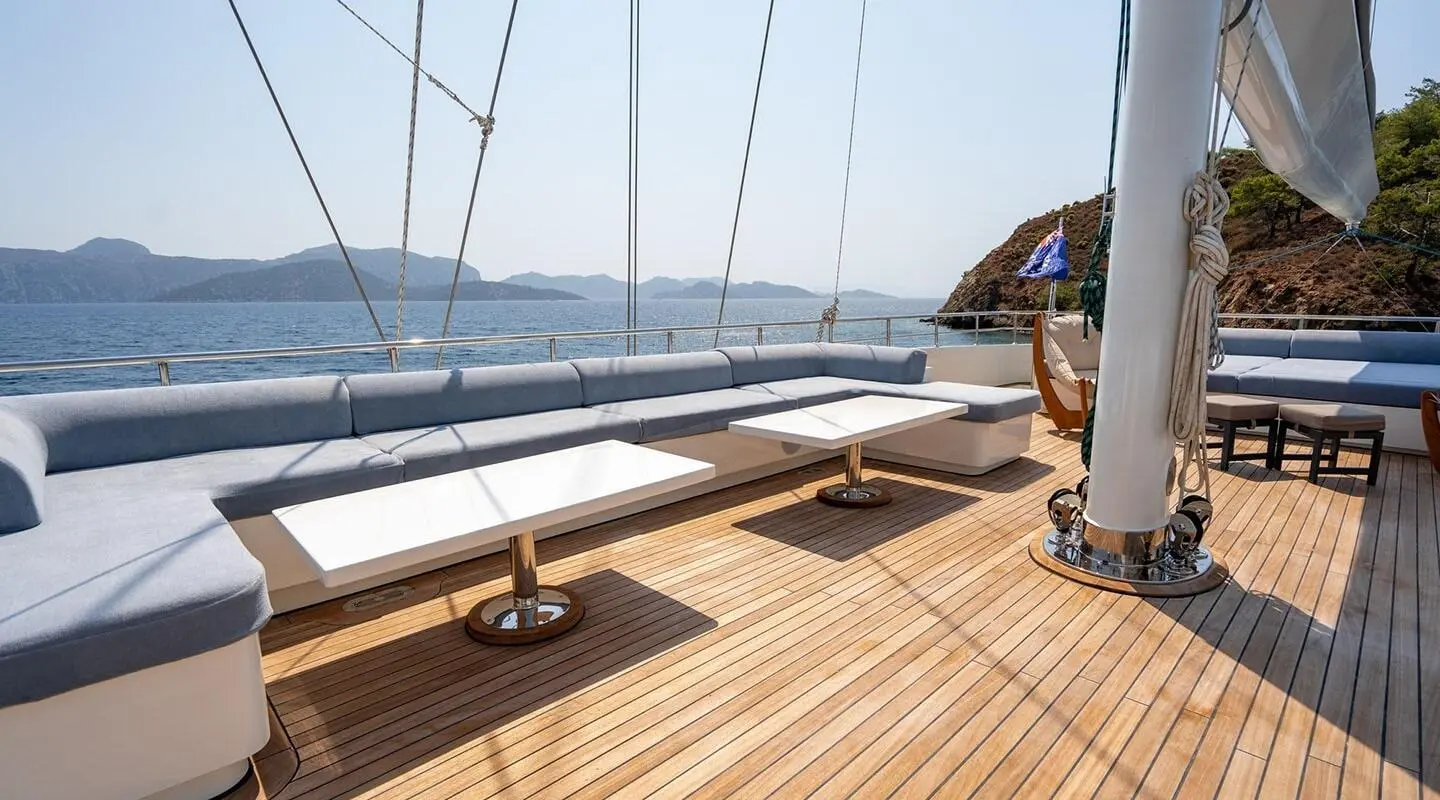 Yacht De Love sunlit teak deck with railing and ocean view