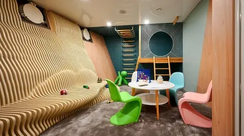 Interior of Ohana yacht with playful playroom, seating, bright colors, and stairs