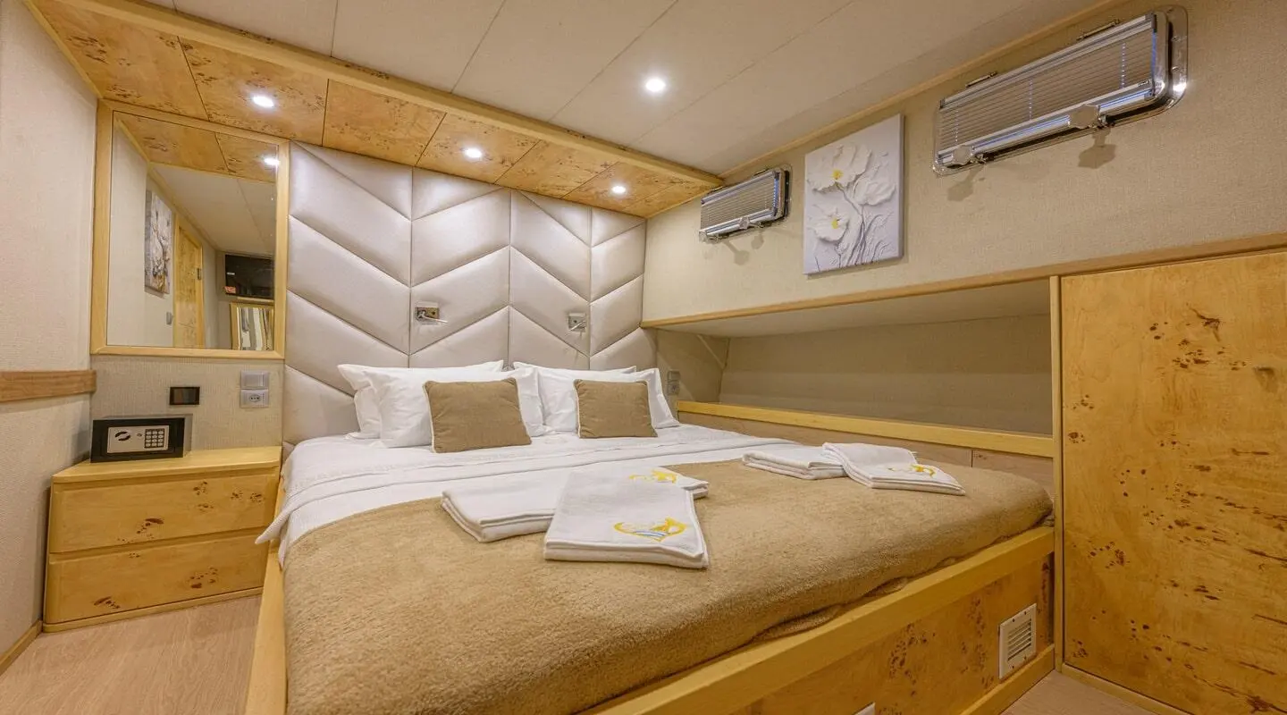 Belgin Sultan yacht cabin with king-size bed, wood paneling, and pillows