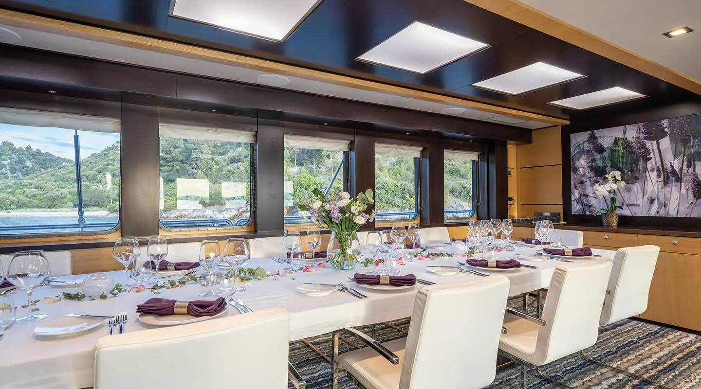 Navilux yacht exterior dining area at sunset with table set and windows