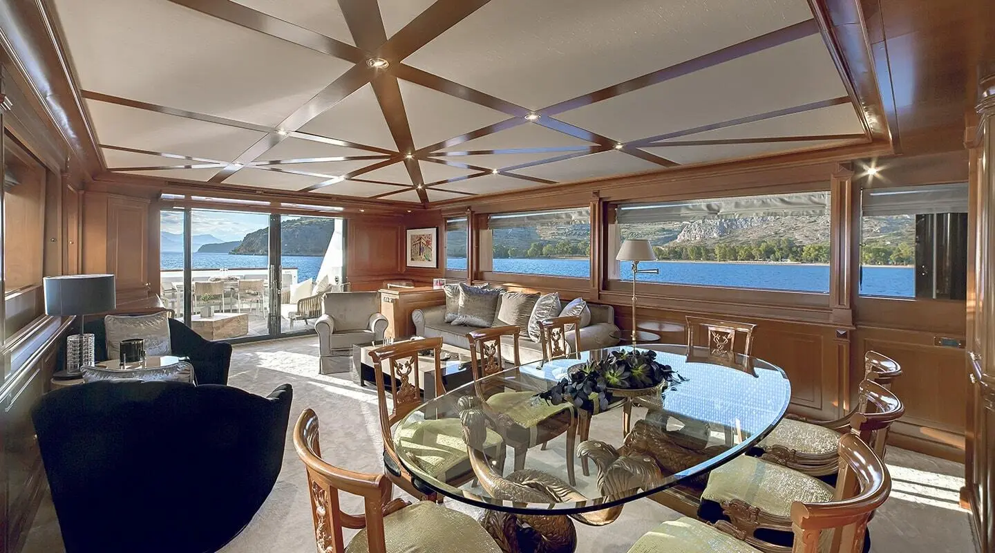 Aquila motor yacht saloon interior with wooden chairs and a dining table