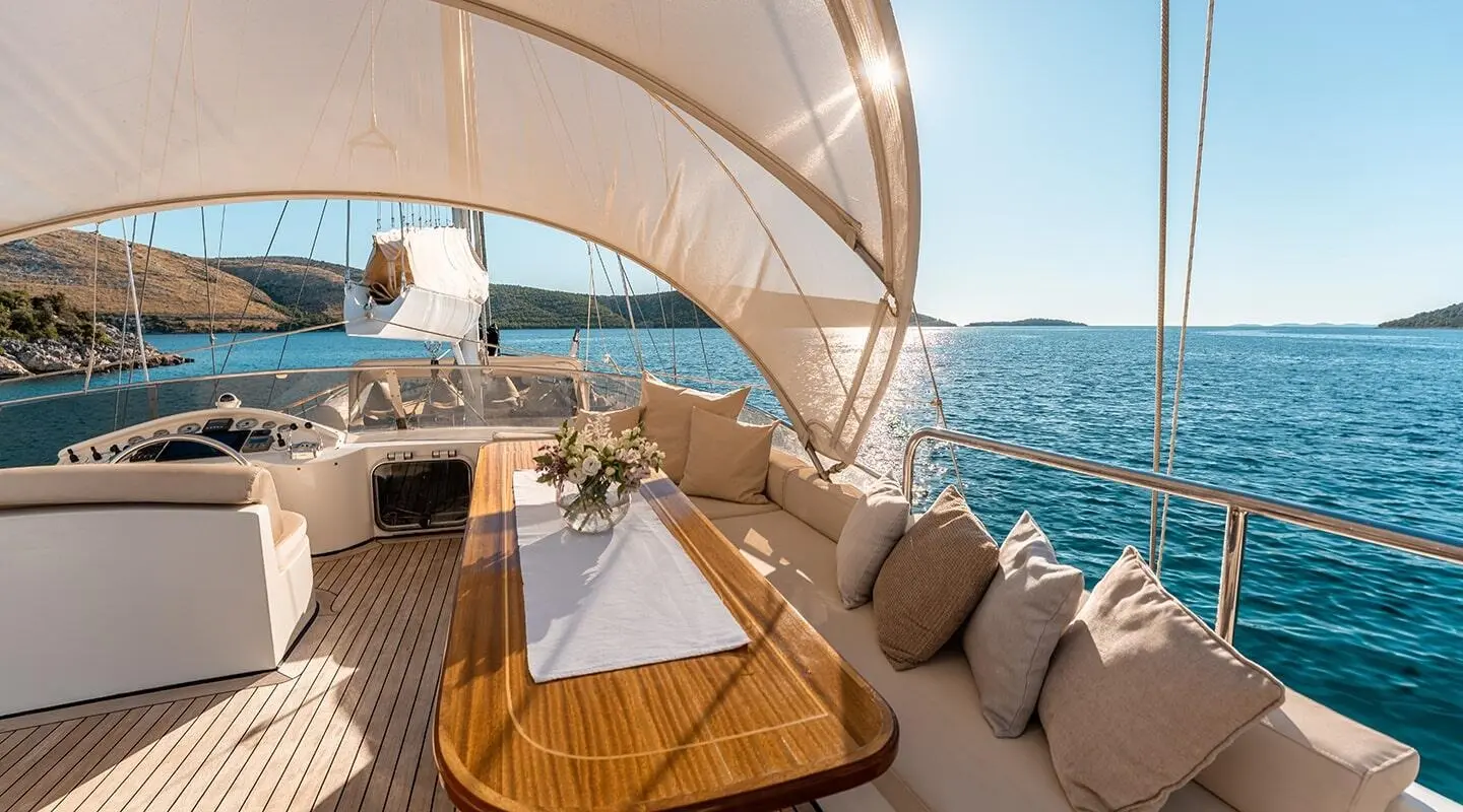 Alessandro I yacht charter deck with beige seating and sunshade over blue sea