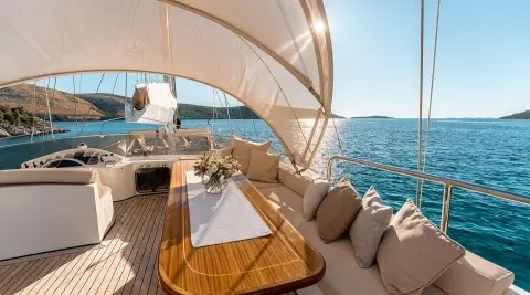 Alessandro I yacht charter deck with beige seating and sunshade over blue sea
