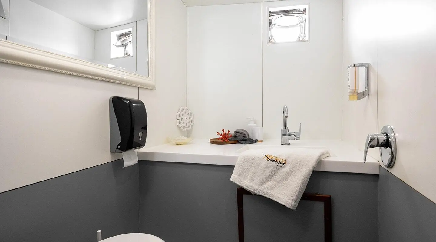 Interior of a yacht bathroom with sink, towel, and window light