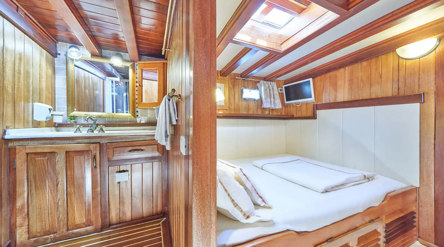 Luxurious yacht Libra interior cabin with wood paneling, bed, and skylight