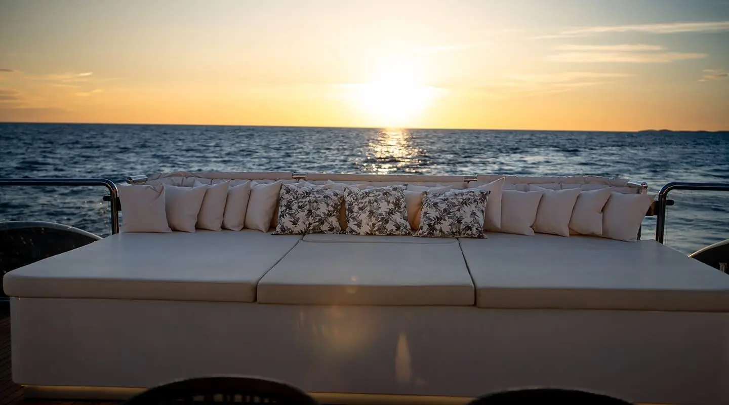 Sunset on the open sea with Nocturno yacht rear deck sofa and cushions