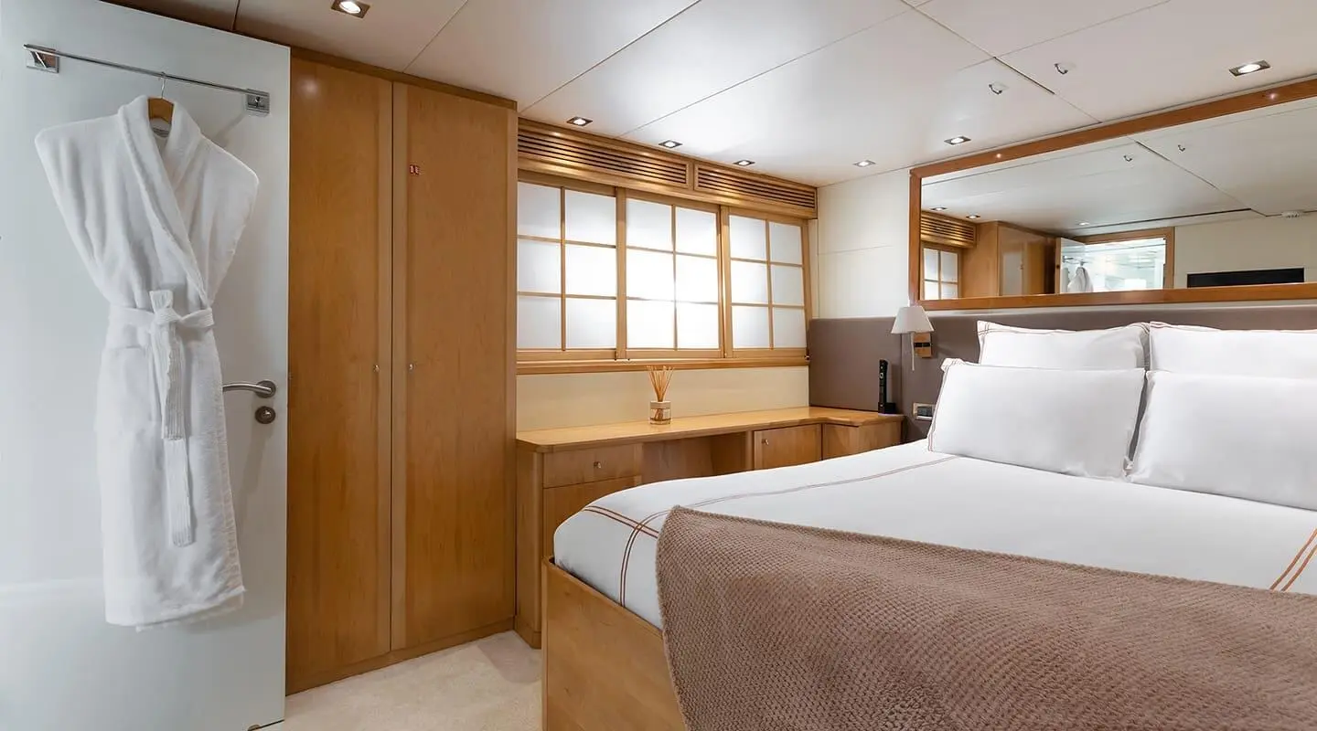 Cosy yacht bedroom interior with wooden cabinetry and a large bed