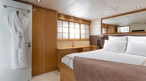 Cosy yacht bedroom interior with wooden cabinetry and a large bed