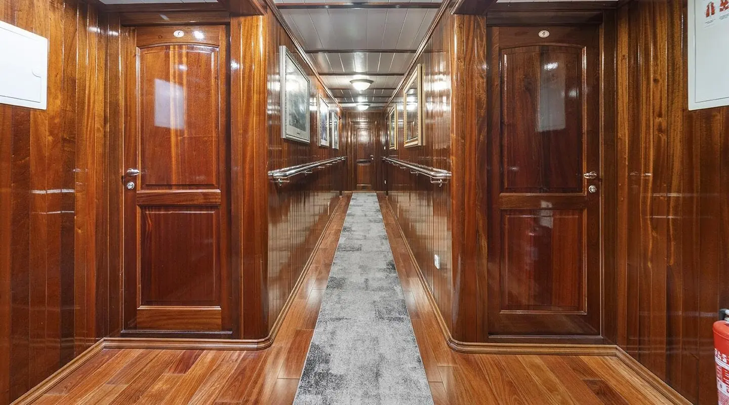 Cesarica gulet hallway with glossy wooden panels and doors lining both sides