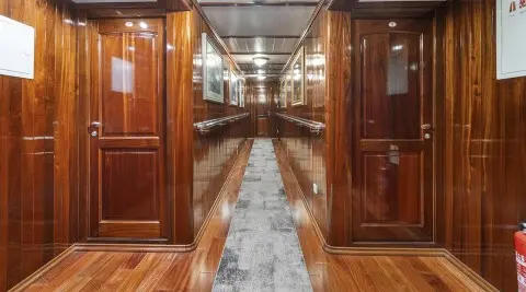 Cesarica gulet hallway with glossy wooden panels and doors lining both sides