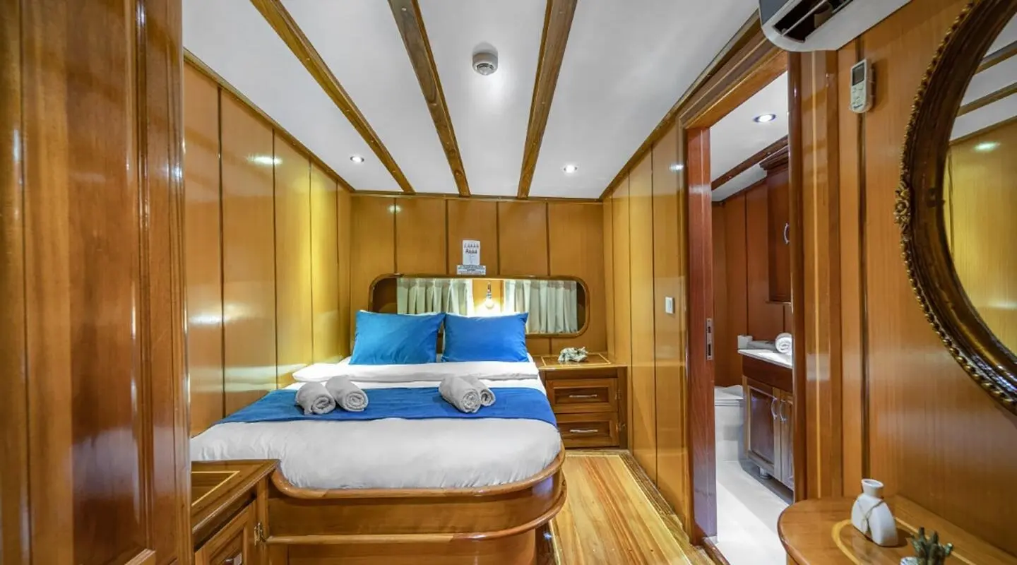 Gulet Tersane 8 interior cabin with double bed, wood paneling, and bunk beds