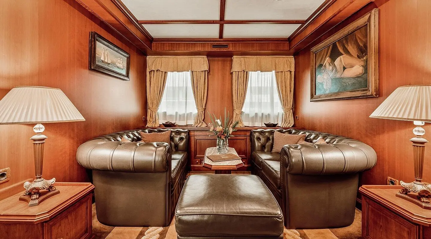 Interior view of Seagull II yacht salon with wood paneling and brown leather seats