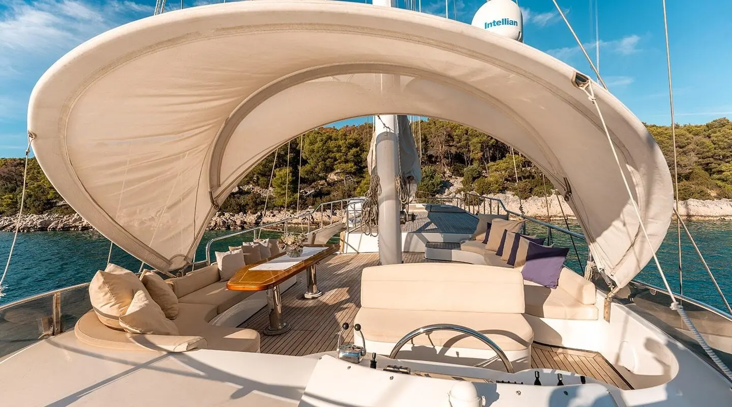 Yacht Alessandro I deck seating area under a canopy at sunset harbor