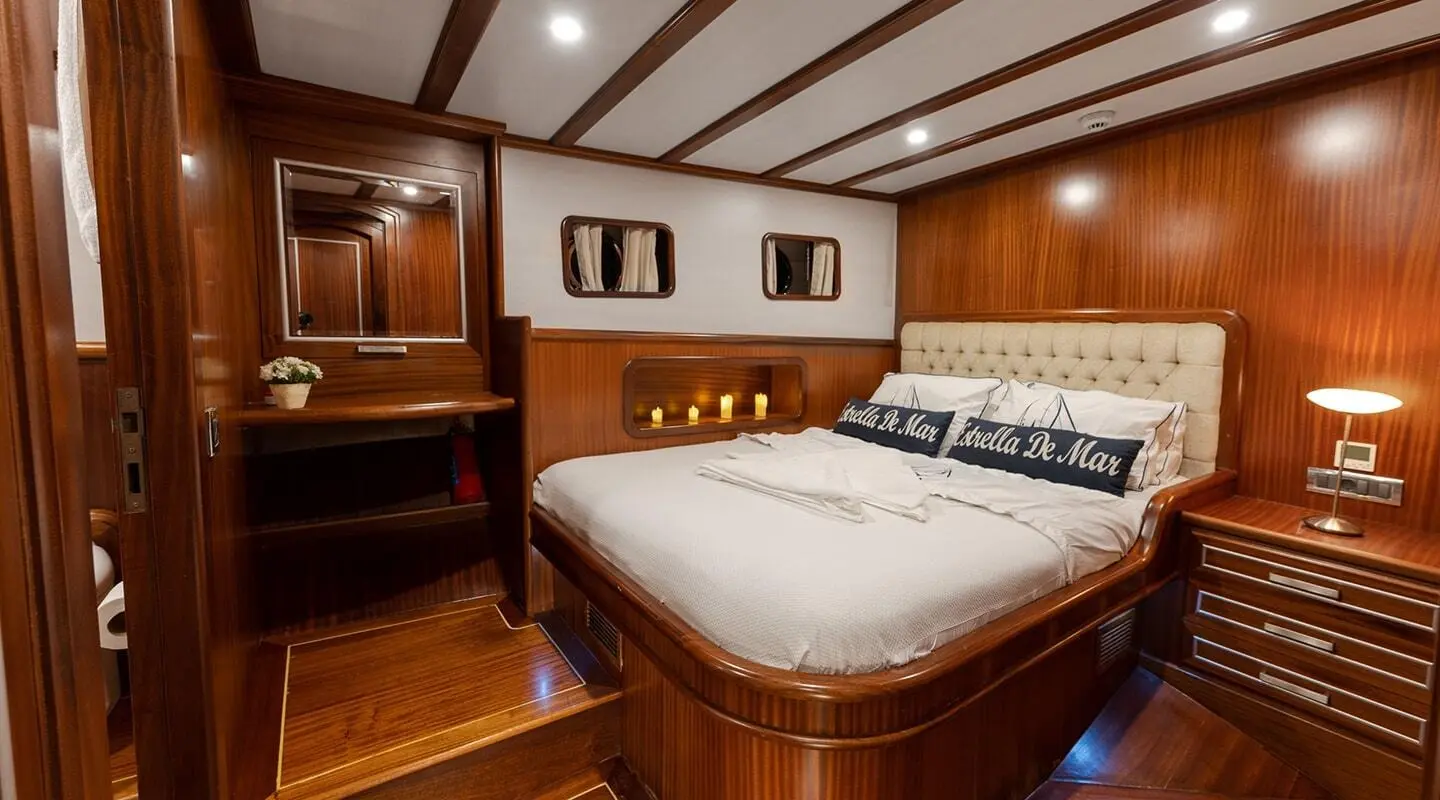 Gulet Estrella De Mar interior with double bed, wooden cabinetry and portholes