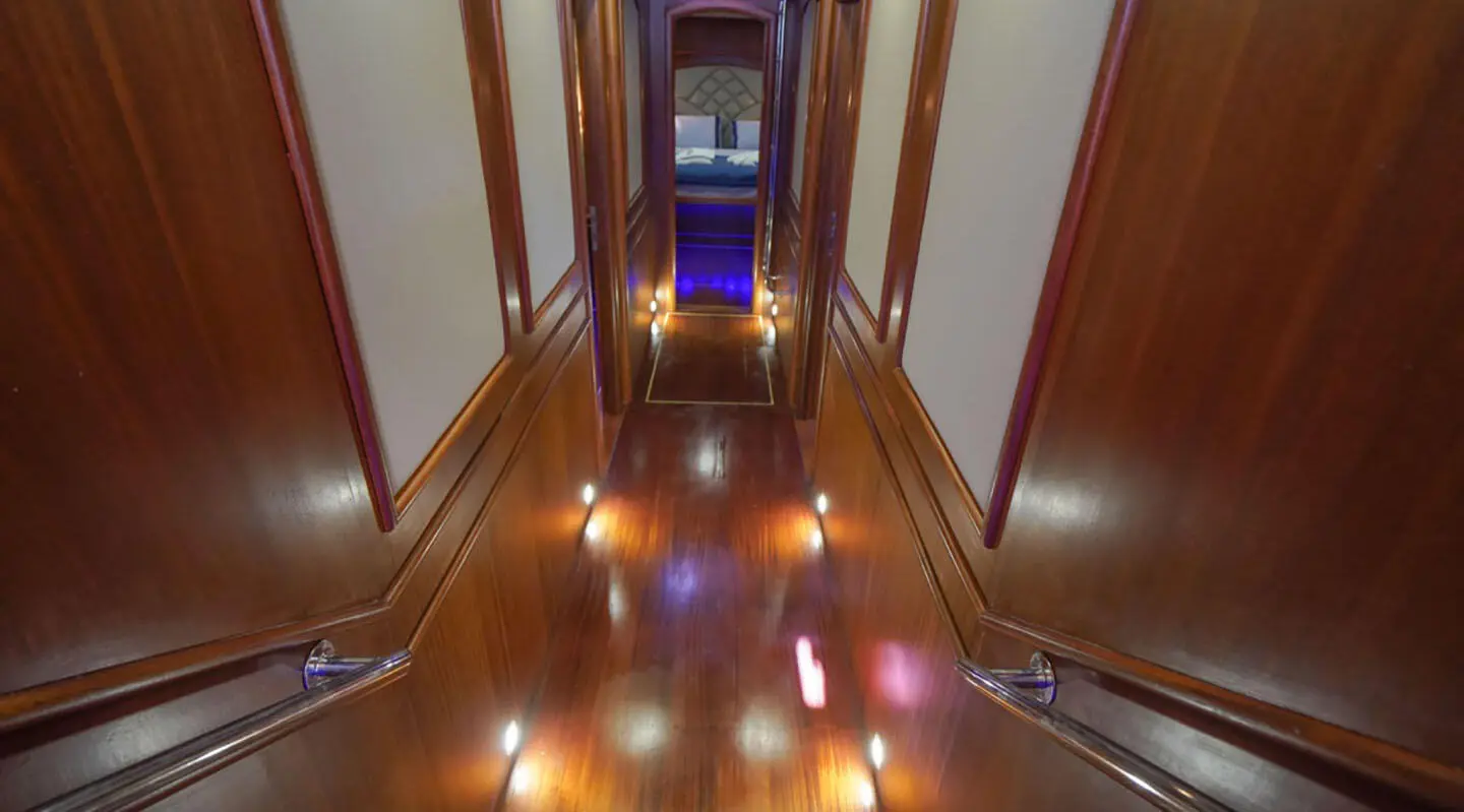 Interior corridor of a luxurious yacht with polished wooden floor and warm lighting