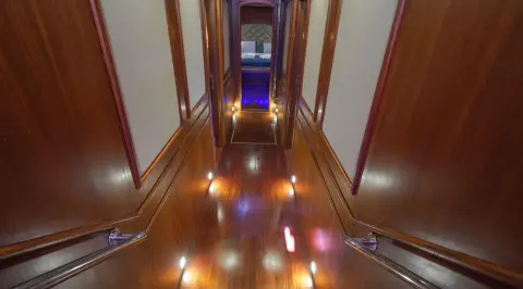 Interior corridor of a luxurious yacht with polished wooden floor and warm lighting