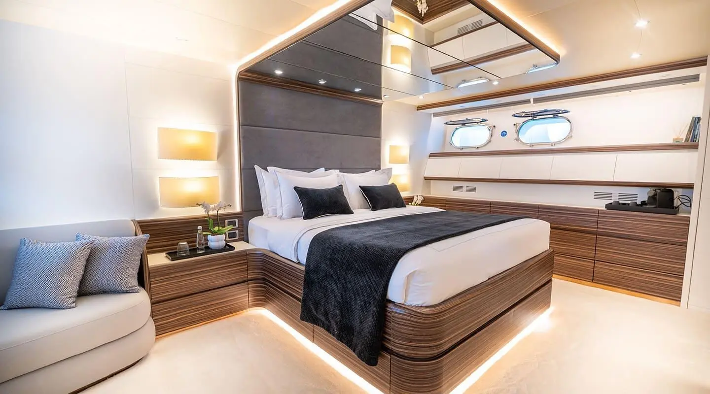 Pareaki II bed deck view: neatly made double bed with dark headboard and bedside lamps