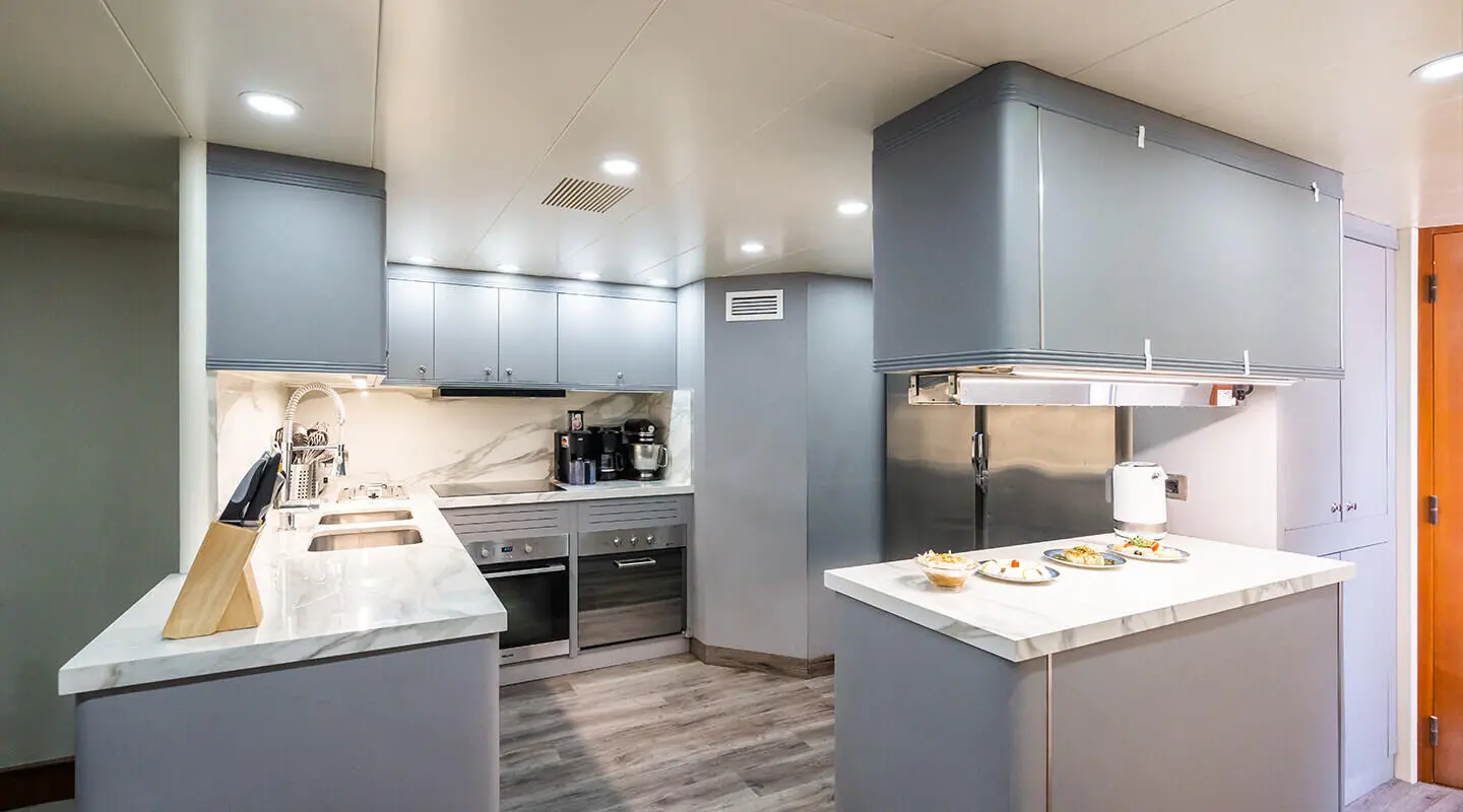 Amadea yacht galley interior with grey cabinets, stove, and counter space